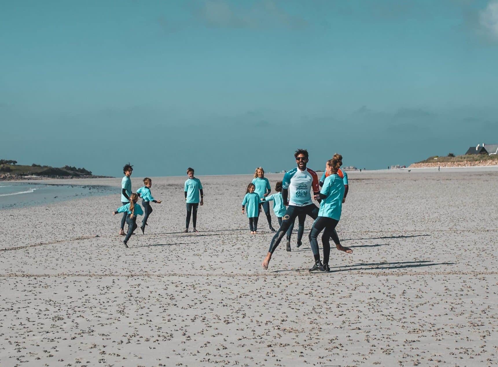 Des stagiaires sur la plage du Dossen pendant leur cours de surf